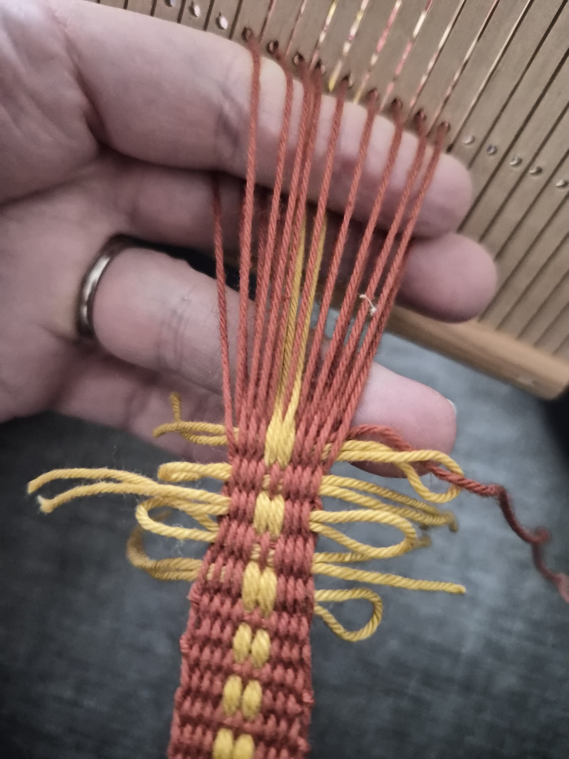 Yarn warped around a table top with two lolly sticks for shed sticks places next to the threads