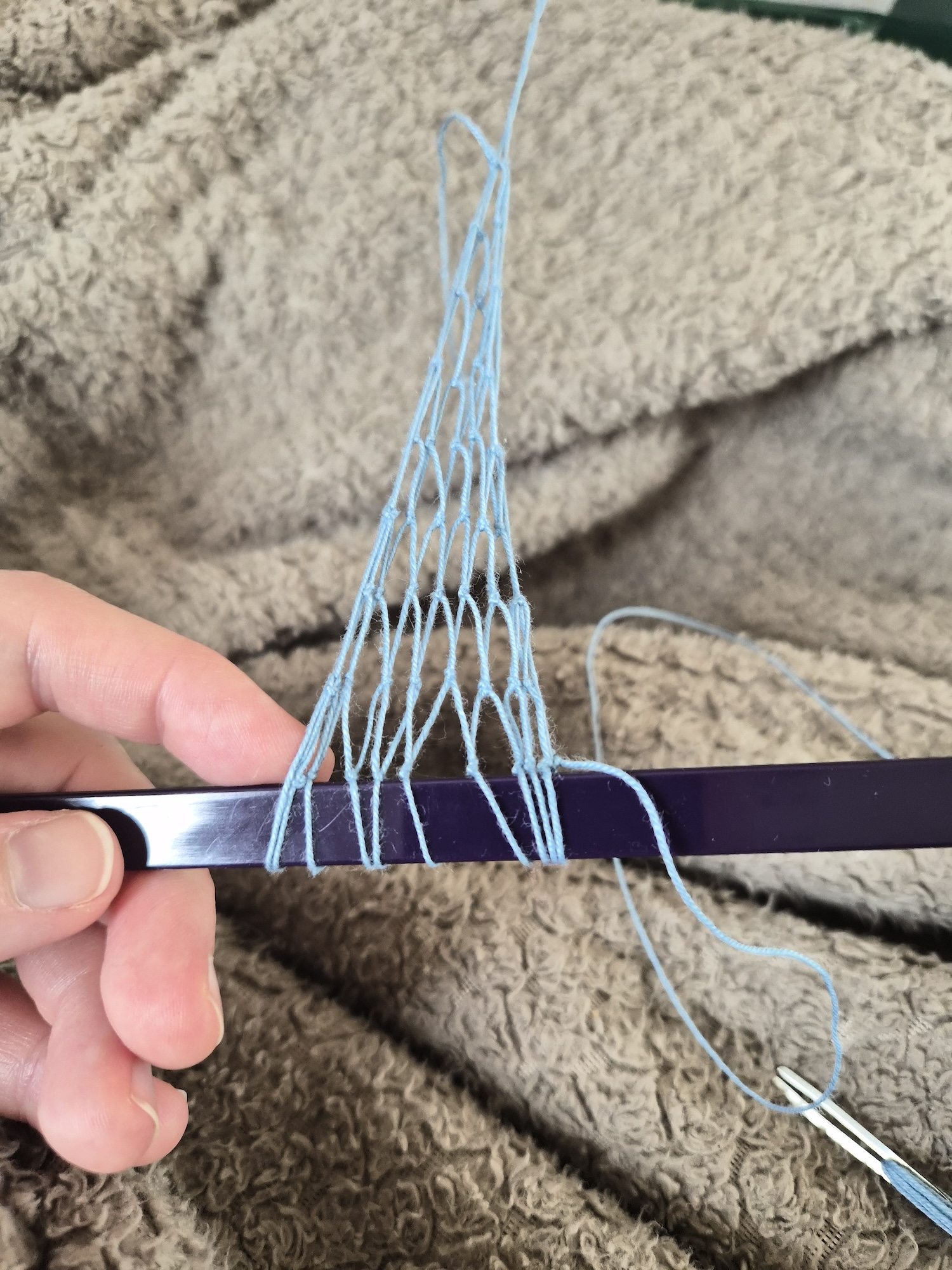 Tying a net, some loops are on the dowel