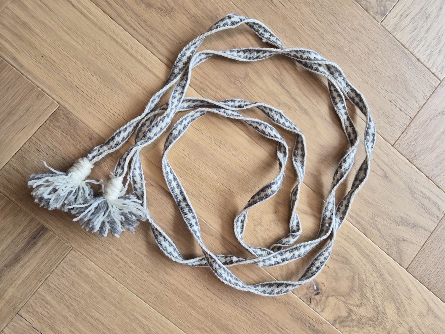 A long tablet woven belt with tassels at each end
