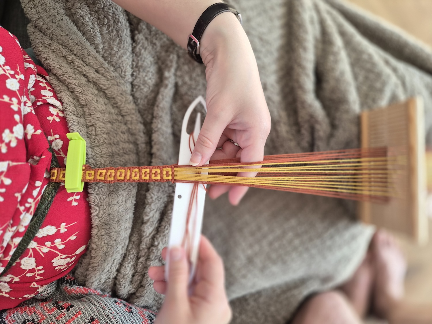 A band being woven on a rigid heddle in a simple pick-up weave