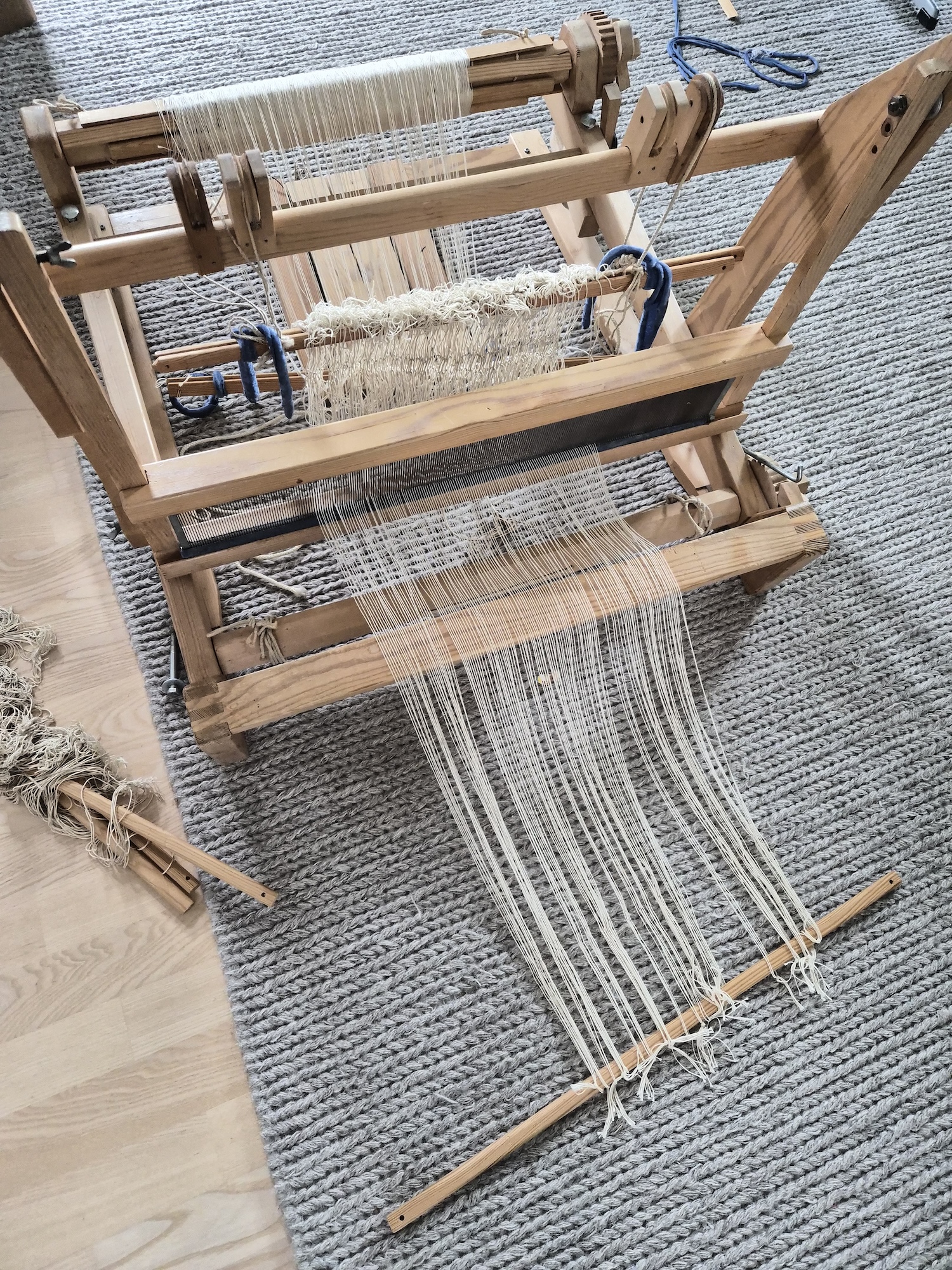 A table mounted loom placed on the floor